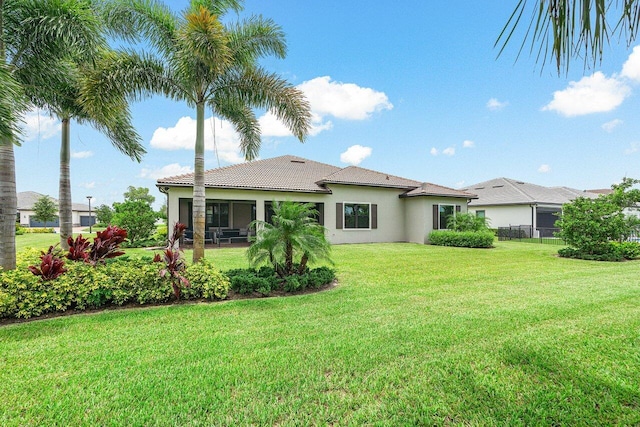 rear view of house featuring a yard