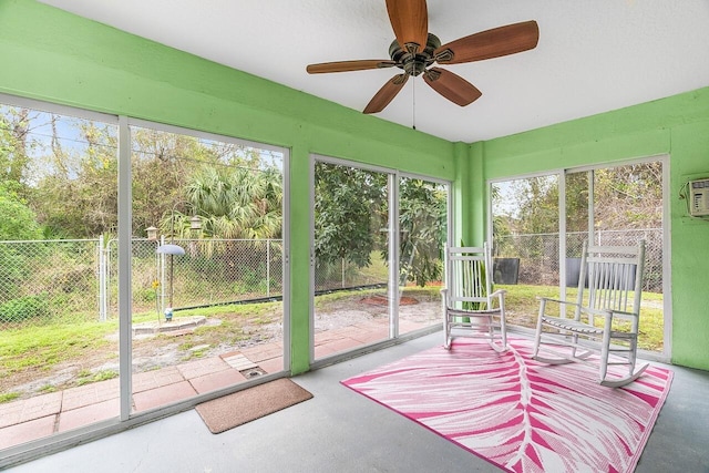 unfurnished sunroom with ceiling fan