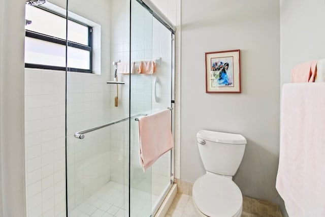 bathroom with tile patterned floors, toilet, and an enclosed shower