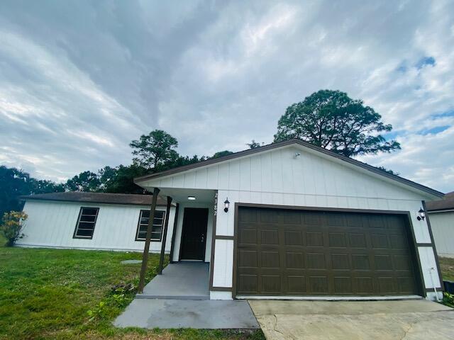 view of front of house featuring a garage and a front lawn