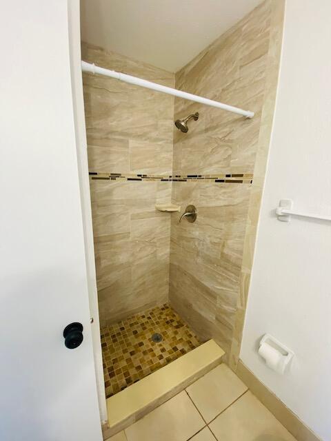 bathroom featuring a tile shower and tile patterned floors