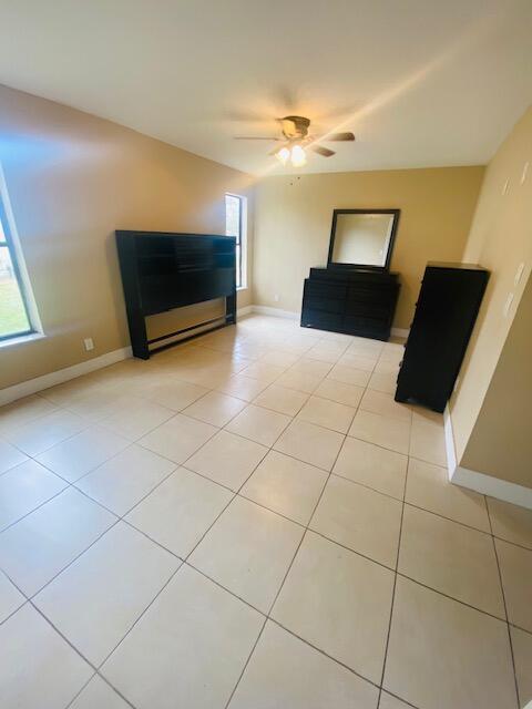 unfurnished living room with plenty of natural light, ceiling fan, and light tile patterned flooring