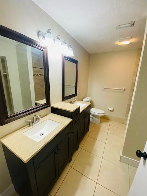 bathroom with tile patterned flooring, vanity, and toilet