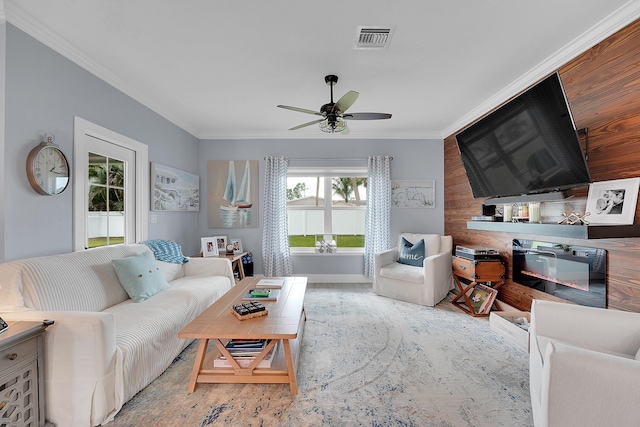 living room featuring ceiling fan, ornamental molding, and wooden walls