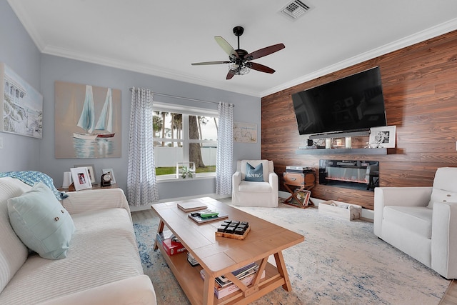 living room featuring crown molding, light hardwood / wood-style floors, ceiling fan, and wood walls