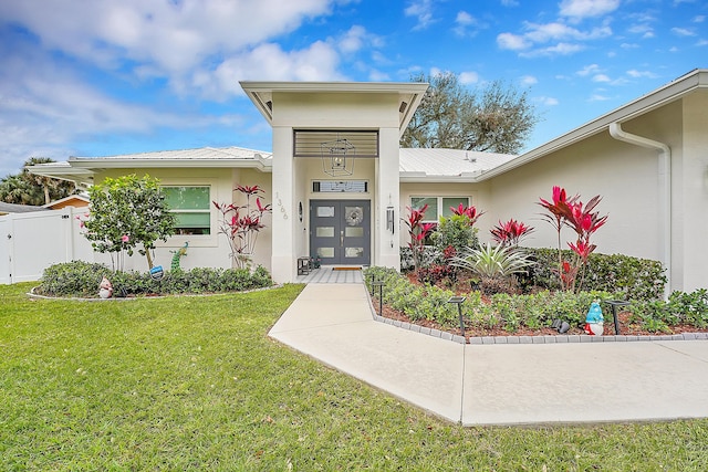 property entrance with french doors and a lawn