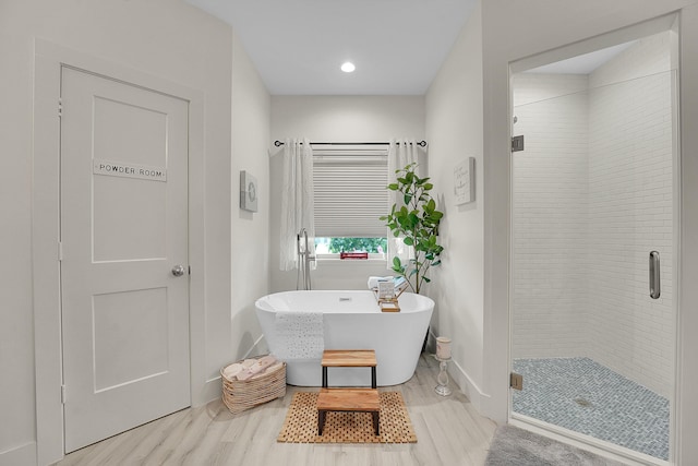 bathroom featuring wood-type flooring and plus walk in shower