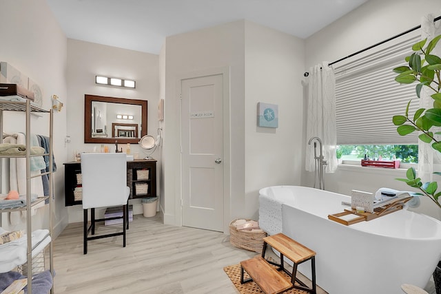 bathroom featuring vanity, hardwood / wood-style floors, and a tub