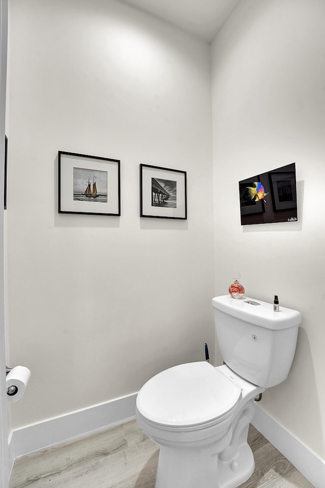 bathroom with hardwood / wood-style flooring and toilet