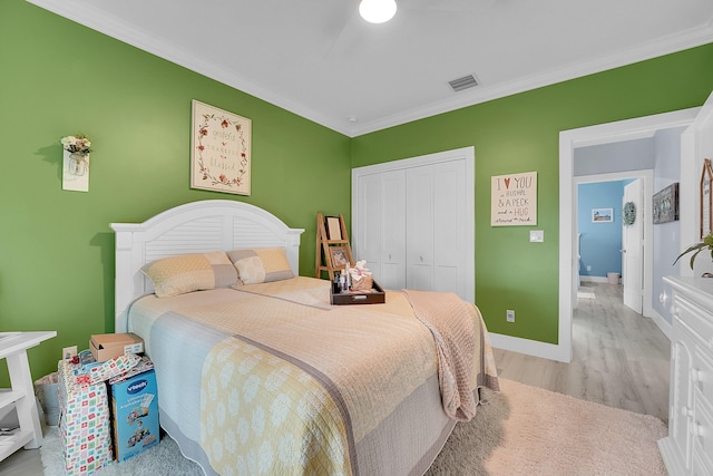 bedroom featuring ornamental molding, a closet, and light wood-type flooring