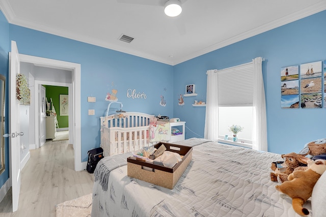 bedroom featuring ornamental molding and light wood-type flooring