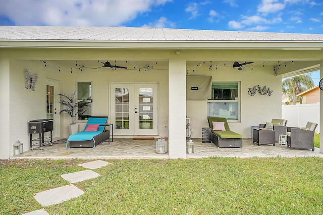 rear view of house with a lawn, a patio area, ceiling fan, and french doors