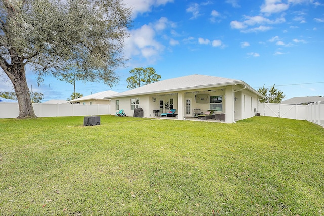 back of property featuring central AC unit, a patio area, ceiling fan, and a lawn