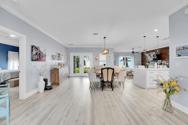 dining area with ornamental molding, french doors, and light wood-type flooring