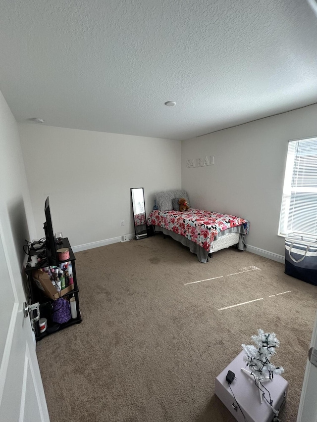 bedroom featuring carpet flooring and a textured ceiling