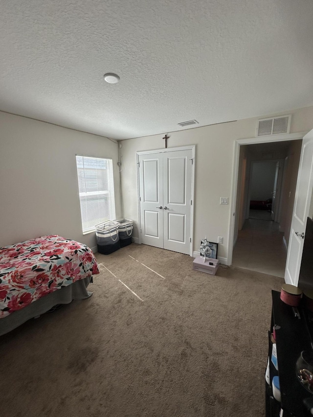 carpeted bedroom featuring a closet and a textured ceiling