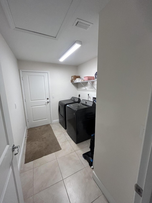 laundry room featuring separate washer and dryer and light tile patterned floors