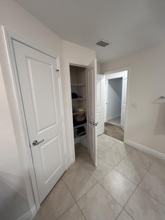 hallway featuring light tile patterned floors