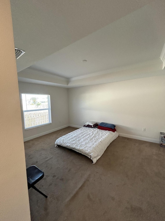 unfurnished bedroom featuring carpet floors and a tray ceiling