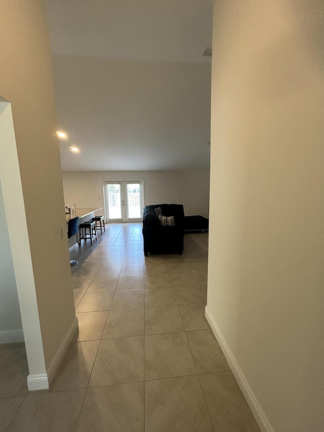 hall with french doors and light tile patterned floors