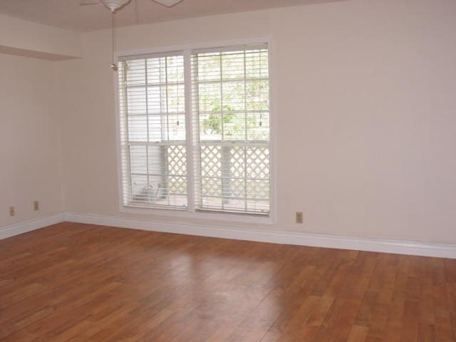 spare room with hardwood / wood-style flooring and ceiling fan