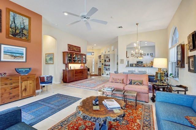 tiled living room with ceiling fan with notable chandelier