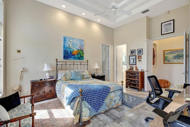 bedroom with a high ceiling, light wood-type flooring, and ceiling fan