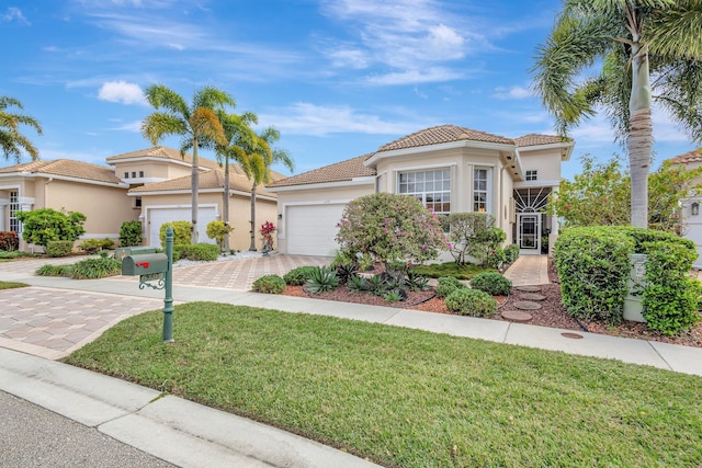 mediterranean / spanish-style house with a garage and a front lawn