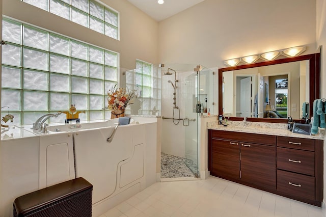 bathroom with vanity, separate shower and tub, and a high ceiling