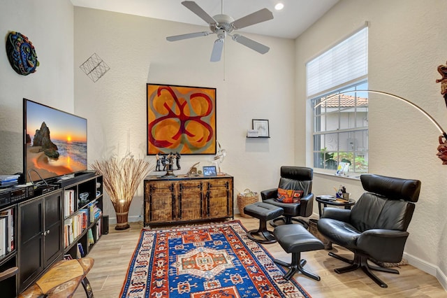 living area featuring light hardwood / wood-style flooring and ceiling fan