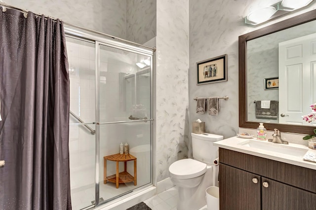 bathroom featuring tile patterned flooring, vanity, toilet, and walk in shower