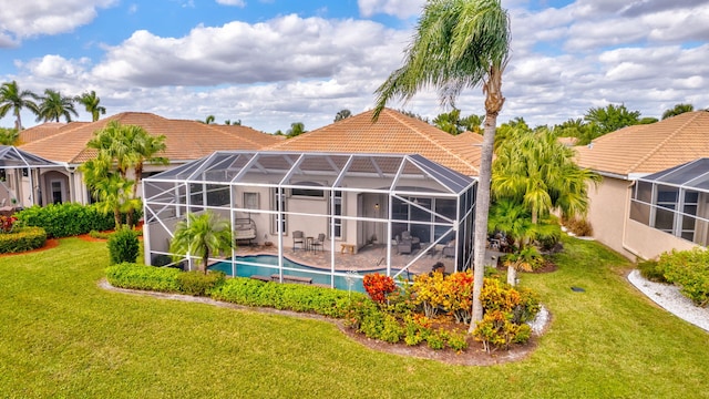 rear view of property featuring a patio, a lanai, and a lawn