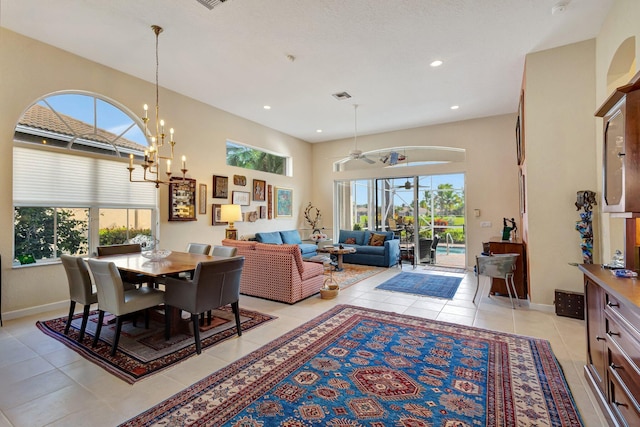 dining space with ceiling fan with notable chandelier and light tile patterned floors