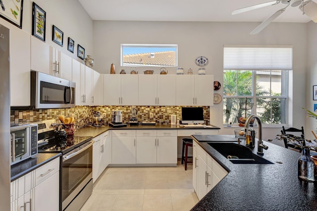 kitchen featuring sink, plenty of natural light, stainless steel appliances, decorative backsplash, and white cabinets