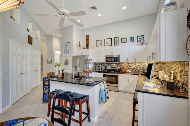 kitchen featuring white cabinetry, stainless steel appliances, and a breakfast bar