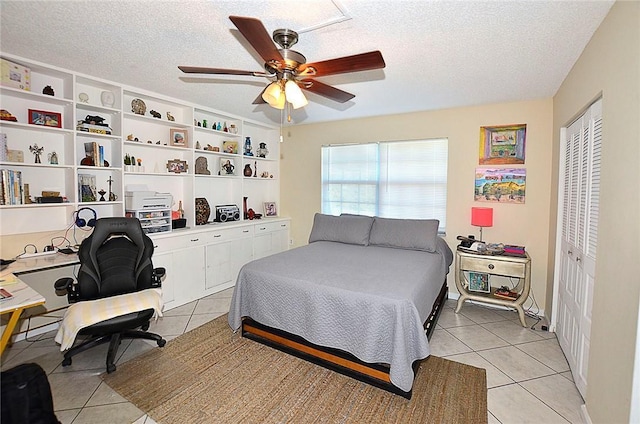 tiled bedroom featuring a textured ceiling, a closet, and ceiling fan