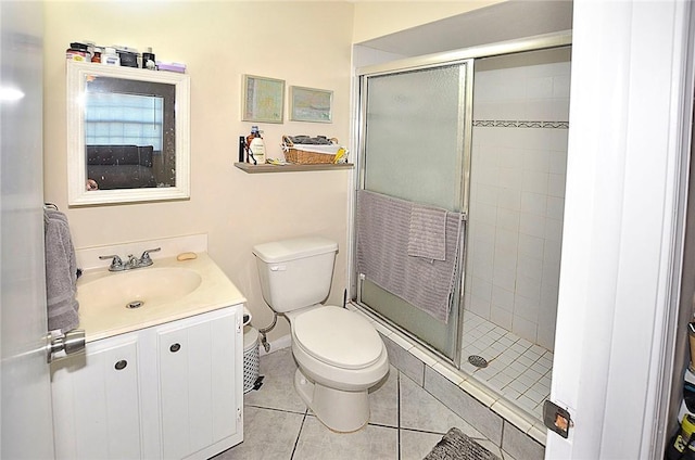 bathroom with tile patterned flooring, vanity, a shower with door, and toilet