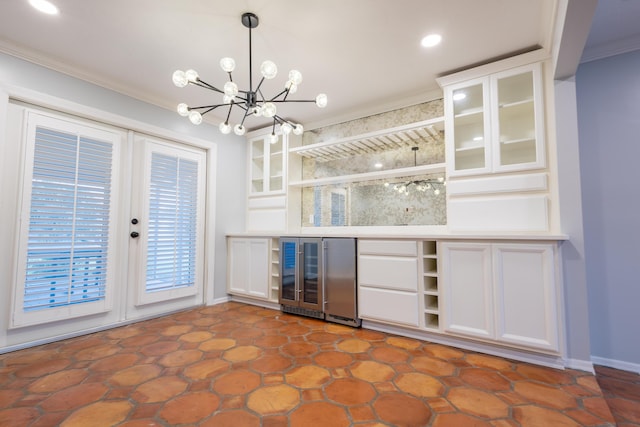 bar featuring wine cooler, decorative light fixtures, ornamental molding, a notable chandelier, and white cabinets