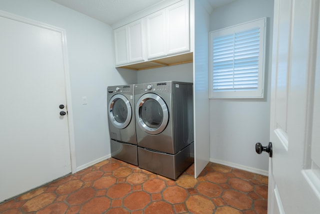 washroom featuring cabinets and washing machine and clothes dryer