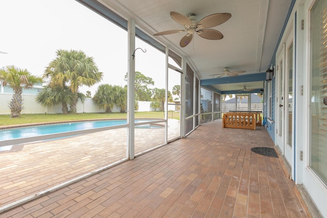 unfurnished sunroom with ceiling fan