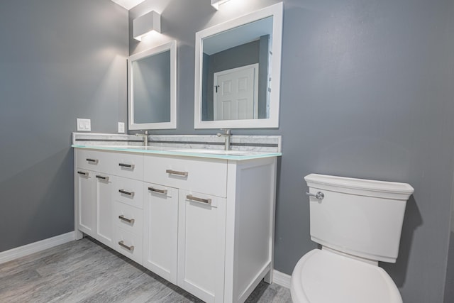 bathroom with vanity, wood-type flooring, and toilet