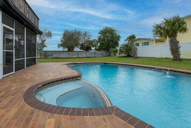 view of pool with a patio, pool water feature, and a lawn