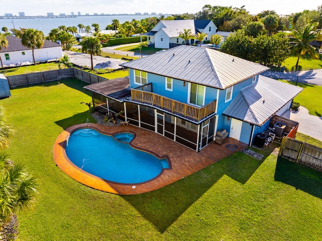 view of swimming pool featuring a water view, a sunroom, and a lawn