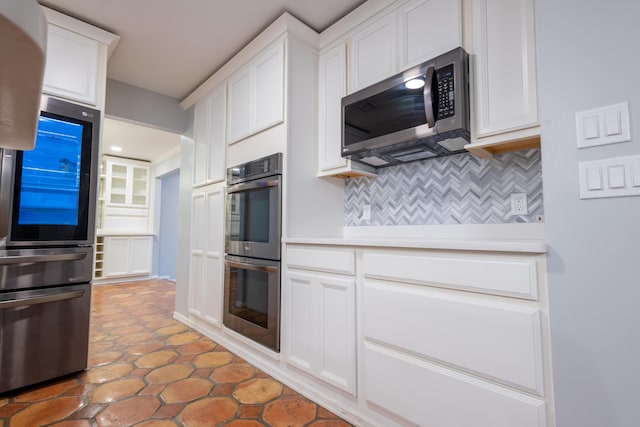 kitchen featuring white cabinetry, stainless steel appliances, and decorative backsplash