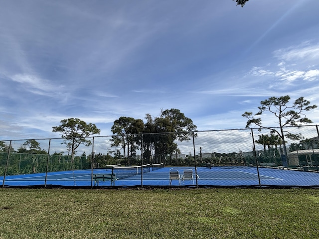 view of sport court featuring a yard and fence