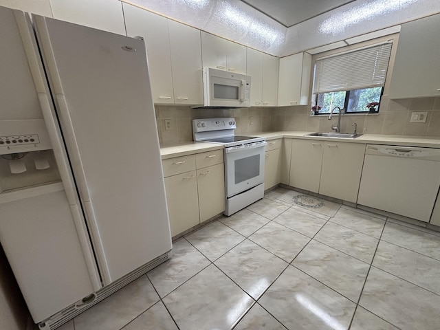 kitchen featuring light tile patterned flooring, white appliances, a sink, light countertops, and backsplash