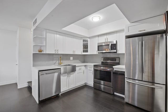 kitchen with sink, dark wood-type flooring, backsplash, stainless steel appliances, and white cabinets