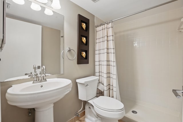 bathroom with a shower with curtain, toilet, and sink