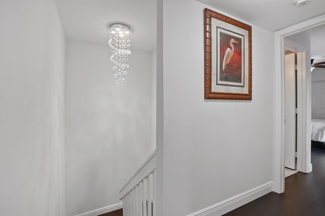 hall featuring dark hardwood / wood-style floors and an inviting chandelier