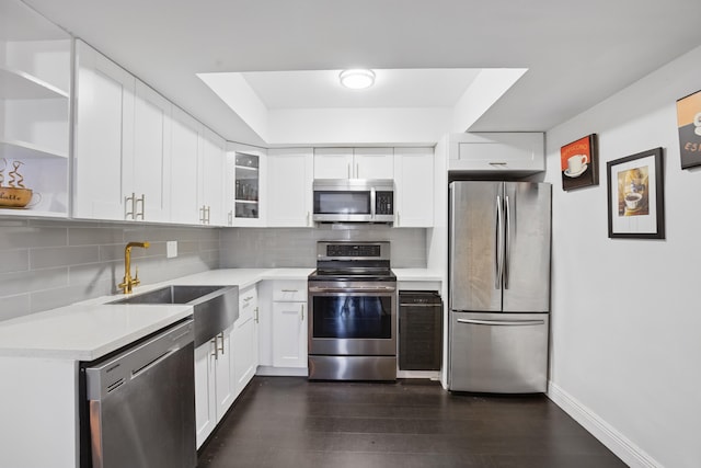 kitchen with stainless steel appliances, white cabinetry, sink, and tasteful backsplash